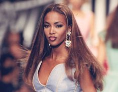 a woman with long hair walking down the runway