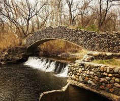 a stone bridge over a small stream in the woods