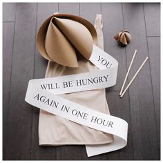 there is a hat and two ribbons on the floor with words that read, you will be hungry again in one hour