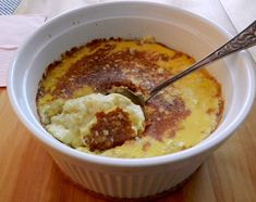 a white bowl filled with food on top of a wooden table