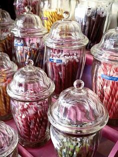 many glass jars filled with different types of candy