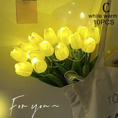 a white tote bag with yellow tulips in it and the words for you