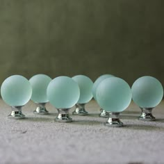 six glass balls are lined up in a row on the floor, with one being turned upside down