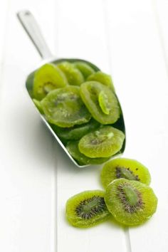 sliced kiwis in a spoon on a white table