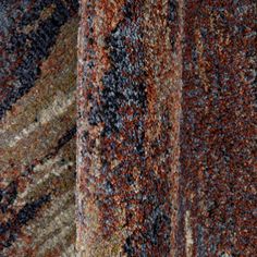 an area rug with different colors and patterns on the carpet, including brown, blue, red