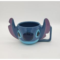 a blue and purple cup with an elephant face on it's side, sitting in front of a white background