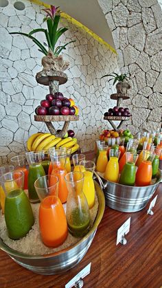 there are many different types of juices on the buffet table, including oranges and green smoothies