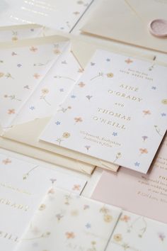 the wedding stationery is laid out on top of each other, including cards and envelopes