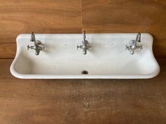 three faucets are mounted on the wall above a sink