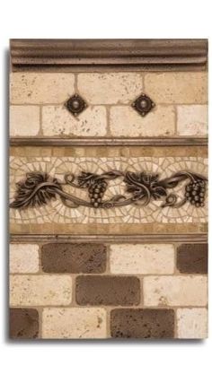 a brick wall with an ornate design on the top and bottom part, in shades of brown