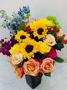 a vase filled with lots of different colored flowers