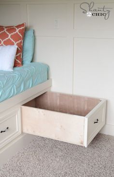 a bed with a blue comforter and white drawers