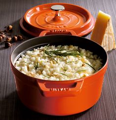 an orange pot filled with rice and garnished with herbs next to other items