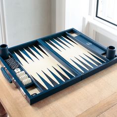 a backgamzer set up on top of a table with two cups and dice