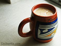 a coffee cup sitting on top of a table next to a keyboard