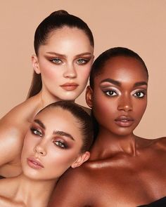 three beautiful women posing for the camera with their arms around each other's shoulders