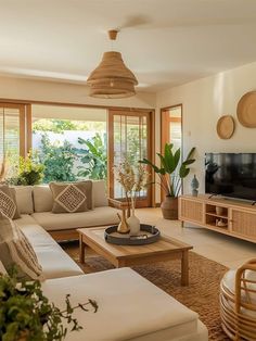 a living room filled with furniture and a flat screen tv mounted on a wall next to a window