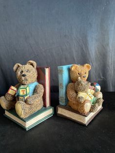 two teddy bears sitting next to each other on books