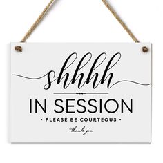 a white sign hanging from a rope with the words shilb in session on it