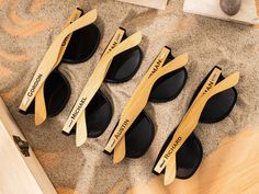 four pairs of wooden sunglasses are on the sand