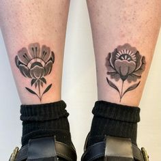 a woman's legs with tattoos on them and flowers in the middle of her leg