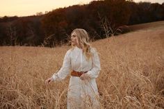 a woman is standing in the middle of a field