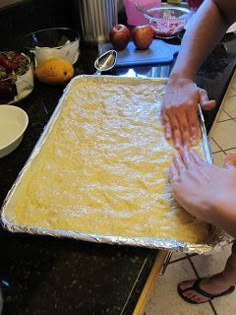 two hands reaching for food on a pan