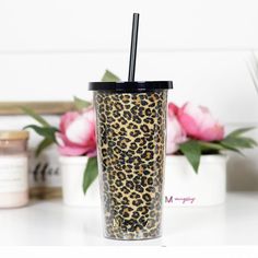 a leopard print tumbler cup with a straw in it