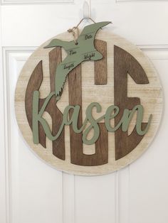 a wooden sign that says kleenn with a bird hanging from it's side