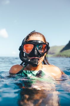 a woman wearing a diving mask and goggles in the water