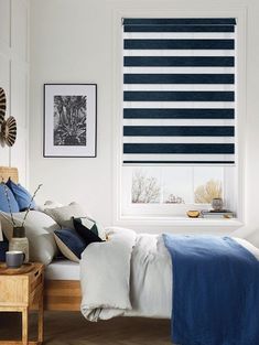 a bedroom with blue and white striped blinds in the window