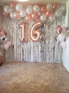 a room filled with balloons and streamers in the shape of number sixteen on it