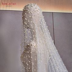 a white wedding veil with pearls on it