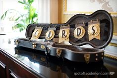 a guitar case sitting on top of a table with some decorations in the shape of words