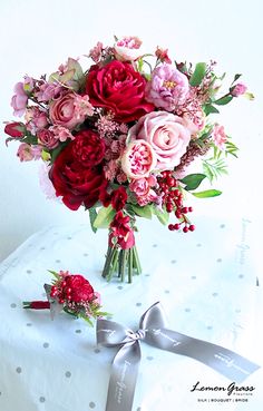 a bouquet of flowers sitting on top of a table next to a ribbon and bow