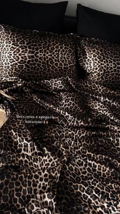 a leopard print bed spread with black pillows