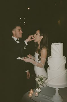 a bride and groom feeding each other cake