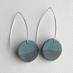 two tone blue and grey earrings with silver hooks hanging from them on a white background