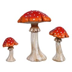 three small red mushrooms sitting on top of each other in front of a white background