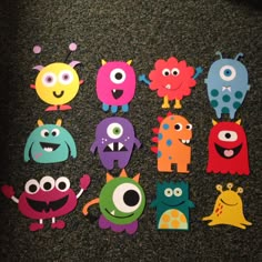 there are many different colored monsters on the floor with one eye and two arms,