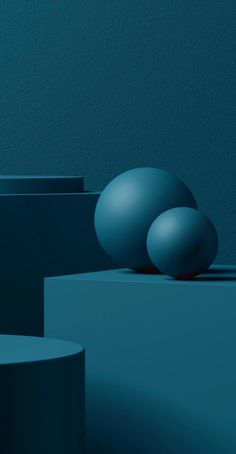 three blue balls sitting on top of each other in the middle of a room with walls