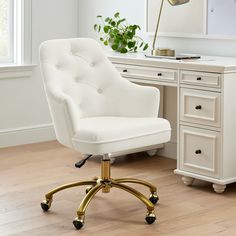 a white office chair sitting in front of a desk with a potted plant on it