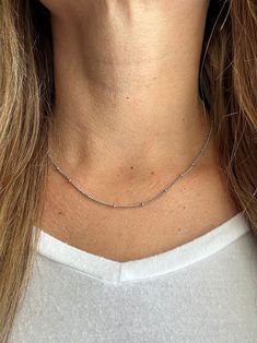 Our favorite layering chain necklace is the Delilah Beaded Satellite chain.    This delicate Stainless Steel or 14K Gold Plated Stainless Steel chain necklace sits close to the neck and features tiny 2mm beads every 2cm.    Wear it on its own for a simple and chic look or pair it with your other favorite necklaces for the ultimate layered look.   Bring instant dimension and flair to your stack with the Delilah Beaded Satellite chain.  Safe for sensitive skin & shower safe. ITEM DESCRIPTION ❤ Choker Necklace ❤ Color:  available in Silver or 14K Yellow Gold ❤ Length: 15 in + 2 in extender ❤ Material: Stainless Steel or 14K Gold Plated Stainless Steel ❤ Sold Individually  ❤ Free Shipping  P R O M O T I O N ✦ 20% Discount is applied for purchases of 2 or more products. Coupon Code: 20FORYOU ✦ Dainty Long Beaded Chain Necklace, Dainty Long Beaded Necklace, Double Strand Beaded Chain Necklaces For Jewelry Making, Double Strand Beaded Chain Necklace For Jewelry Making, Double Strand Satellite Chain Necklace For Gift, Dainty Jewelry With Beaded Chain For Layering, Dainty Beaded Chain Jewelry For Layering, Minimalist Tiny Beaded Necklaces For Layering, Minimalist Beaded Chain Layered Necklace