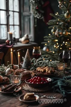 a table set for christmas dinner with candles, cookies and cranberries on it