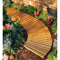 a wooden walkway surrounded by flowers and plants