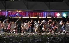 a crowd of people standing next to each other in front of a fence covered in trash