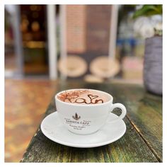 a cappuccino is sitting on a wooden table