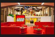 the inside of a lego store with red booths