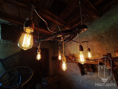 several light bulbs hanging from a wooden beam in an old room with exposed wood beams