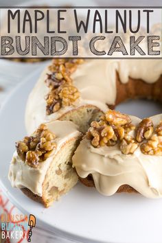 a white plate topped with a bundt cake covered in frosting and walnuts